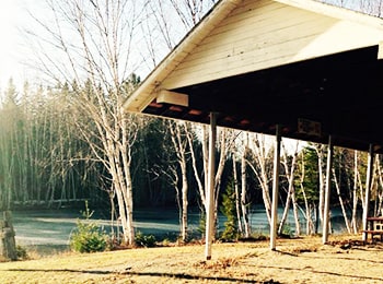 Covered picnic tables next to small lake